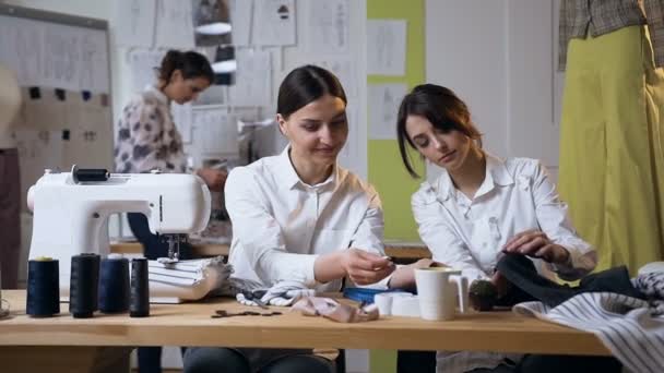 Zwei weibliche Modedesignerinnen, die am zukünftigen Kleidungsdesign arbeiten. — Stockvideo