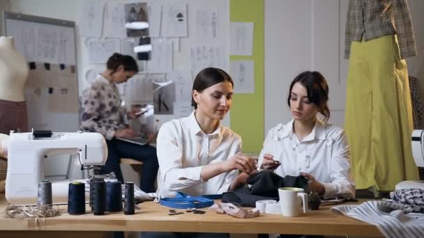 Twee aantrekkelijke jonge vrouw werken in de naai Studio. — Stockvideo
