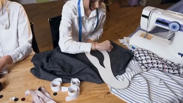 Schneiderinnen zeichnen mit Seifenscheibe auf das Stück Stoff. — Stockvideo