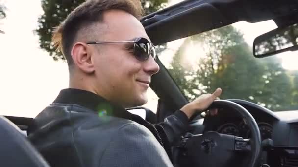 Junger attraktiver Mann am Steuer eines Cabrios. — Stockvideo