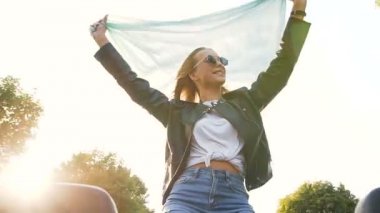 Arabada eğlenen atkı ile mutlu genç kadın.