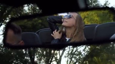 Cabriolet aynasında genç çekici sarışın kadının Yansıması.