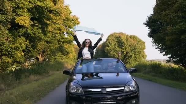 Attraktives junges Paar genießt eine Fahrt im Cabrio. — Stockvideo