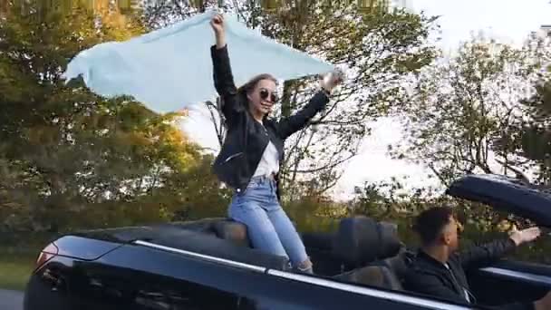 Junge hübsche Mann und Frau genießen eine Fahrt im Cabrio. — Stockvideo