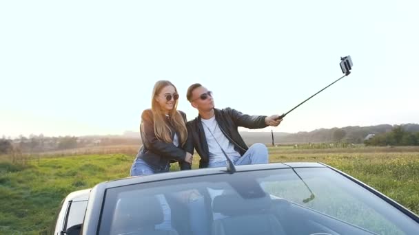 Aantrekkelijke man en vrouw nemen selfie terwijl zittend in de cabriolet. — Stockvideo