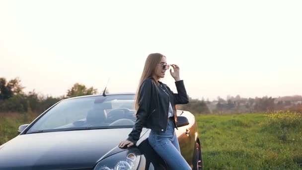 Attraktive junge Frau steht neben Cabrio. — Stockvideo