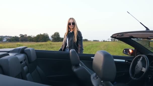 Confident blonde woman opening the door and sitting in cabriolet. — Stock Video