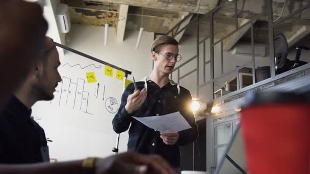 Joven manager masculino presentando nuevo proyecto a su cowoker en la reunión . — Vídeos de Stock