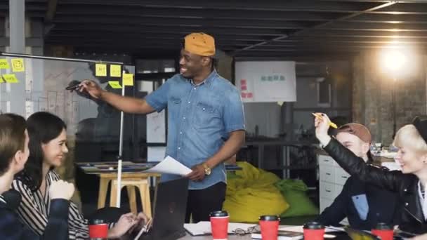 African hipster man presentera resultatet av nya affärsplan till cowoker under affärsmöte på kontoret. — Stockvideo