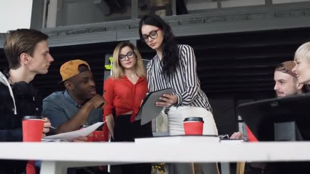 Une jeune femme d'affaires présente son nouveau plan d'affaires à une jeune équipe hipster lors d'une conférence . — Video