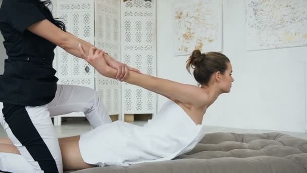 Kvinnlig terapeut stretching ung sport kvinna i kliniken. — Stockvideo