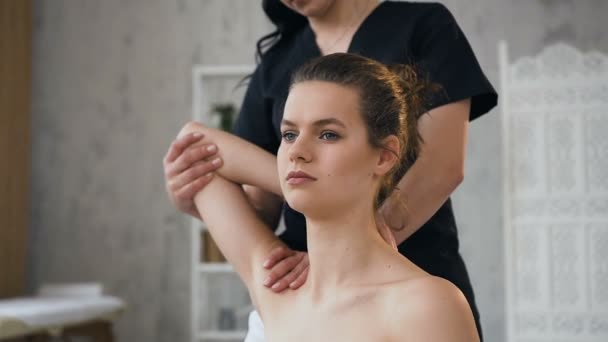 Professionele jonge therapeut stretching vrouwelijke patiënt in kliniek. — Stockvideo