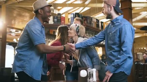Pięć szczęśliwych Multi etnicznych przyjaciół powitanie siebie w pubie, bar. — Wideo stockowe