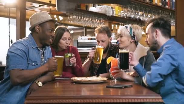 Beş mutlu hipster arkadaş sohbet, gülmek ve içecek kokteyl ve bira barda, pub. — Stok video