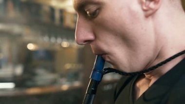 Bar arka planda çekici genç adam sigara nargile.