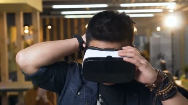 Japoński człowiek biznesu ubrany w wirtualną rzeczywistość okulary VR na nowoczesnym tle biurowym. — Wideo stockowe
