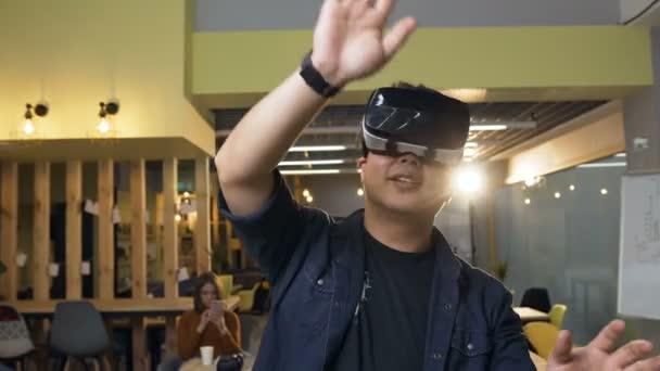 Koreanischer Geschäftsmann arbeitet mit Virtual-Reality-Brille auf modernem Bürohintergrund. — Stockvideo