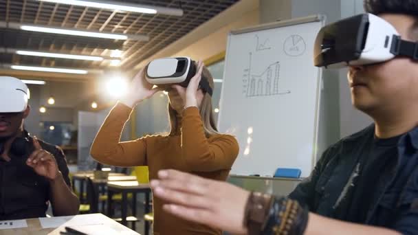 Сосредоточенная команда сотрудников, использующих очки виртуальной реальности в современном офисе . — стоковое видео