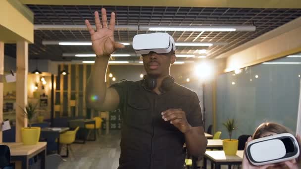 Jeune homme concentré en réalité virtuelle VR lunettes de travail dans le bureau . — Video
