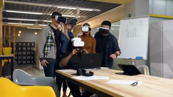 Junges Business-Team mit Virtual-Reality-Brille blickt auf den Laptop und feiert erfolgreichen Deal mit Kunden. — Stockvideo