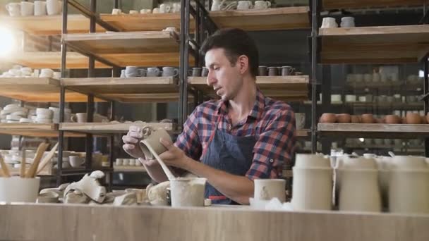 陶器で陶器の帽子を作る白人男性陶芸家. — ストック動画