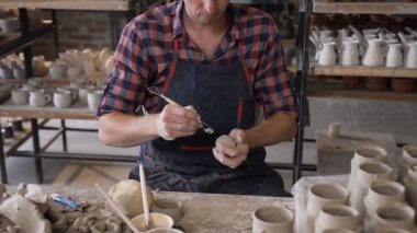 Odaklanmış erkek çömlekçi kilden bir şey yapma.