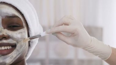 Genç güzel afro amerikan kadın yoğurt yüz maskesi cilt bakımı, beyaz arka plan üzerinde güzellik tedavileri uygulayarak. Sağlıklı, sincare ve gençleştirme kavramı
