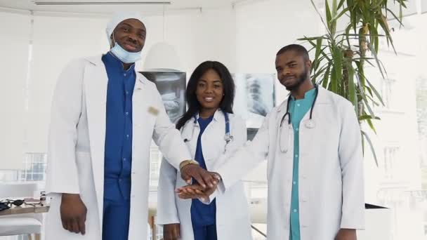 Портрет команди усміхнених лікарів, які дивляться на камеру в медичному кабінеті . — стокове відео