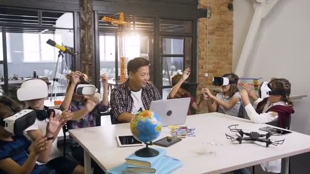 Νέος Κορέας δάσκαλος με έξι Καυκάσιοι νέοι μαθητές χρησιμοποιώντας επαυξημένης πραγματικότητας VR γυαλιά σε μια επιστημονική τάξη δημοτικού υπολογιστή — Αρχείο Βίντεο