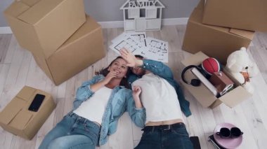 Mutlu çift karı koca yeni dairede yerde yatan konuşma ve taşıma işlemi sırasında etrafa bakıyor. İlişki ve ev kavramı.