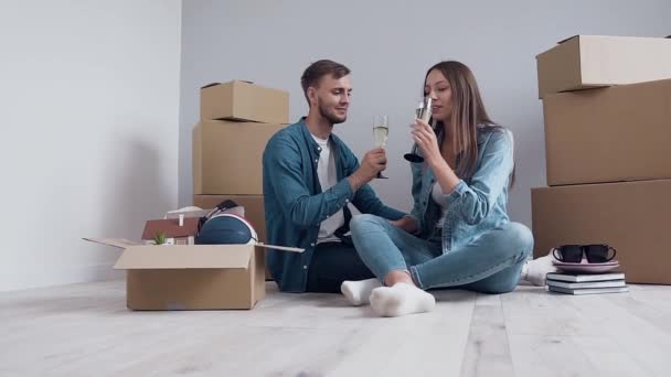 Cute happy couple clinking and drinking champagne in new flat, house. — Stock Video