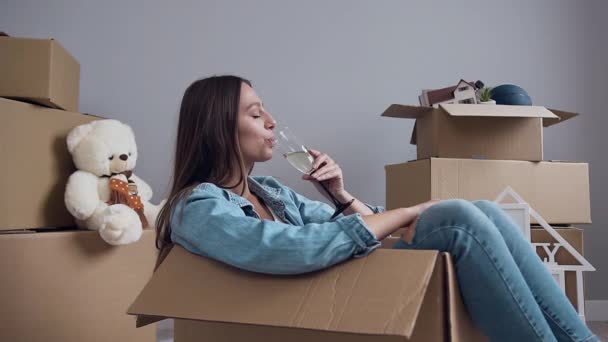 Aranyos boldog nő iszik pezsgőt belül csomagoló doboz. — Stock videók