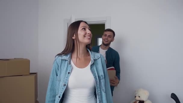 Młoda szczęśliwa Rodzina otwarcie drzwi i chodzenie w pustym pomieszczeniu nowego domu, mieszkanie. — Wideo stockowe