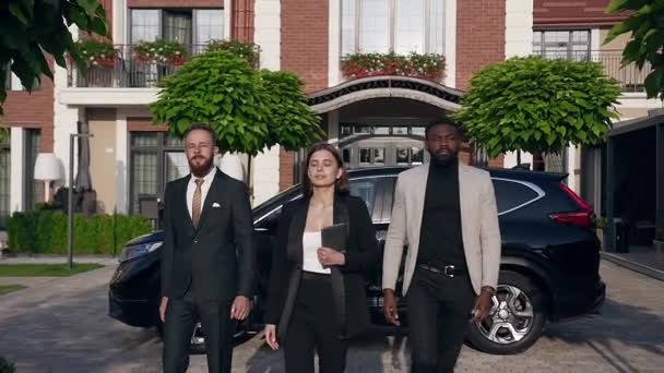 Slow motion of successful young male and female businessteam walking on the street in black-white costumes — Stock Video