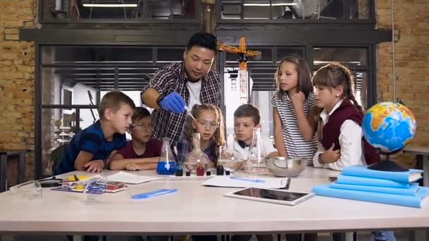 Insegnante di chimica insegna ai giovani studenti a fare esperimenti di reazione chimica in classe di laboratorio — Video Stock