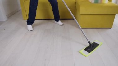 Ahşap parke wipping sırasında dans kulaklık ile Gülümseyen kadın temizlik işçisi