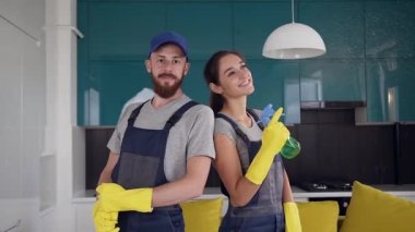 Mutfağın ortasında duran mavi üniformalı temizleyicilerin güler yüzlü ekibi