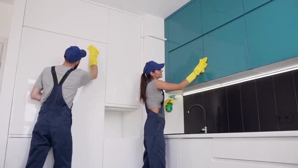 Felice gente sorridente dell'ufficio di pulizia pulire i mobili della cucina con spray e stracci — Video Stock
