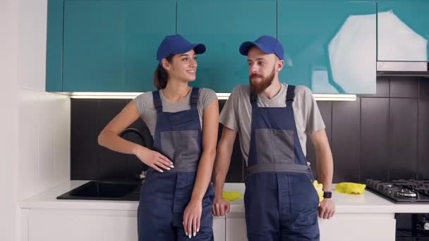 Spokojený s tím, že jejich pracovní muž a žena z čisticího servisu dávají pětku v modro-černé kuchyni