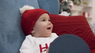 Rahat kol sandalyeve kadın el burnuna dokunmadan oturan bobble şapka gülümseyen sevimli bebek kız