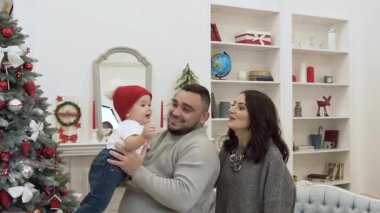 Sevimli bebek ile mutlu aile şenlikli dekore noel odasında sevinçle vakit geçirmek