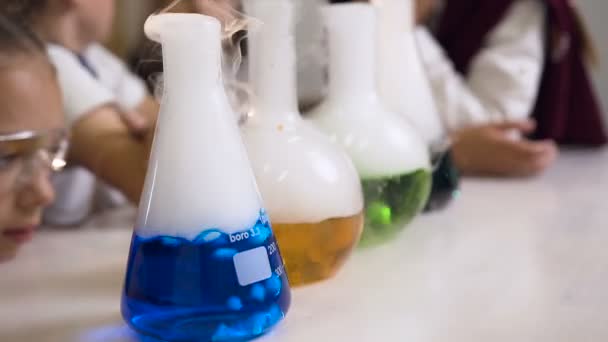 Primer plano de los vasos de precipitados químicos y frascos con líquido coloreado donde se evapora el humo frío. Experimento químico — Vídeos de Stock