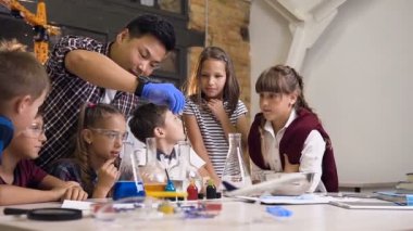 Koreli bilim adamı genç okul çocukları kimyasal reaksiyon deneyleri bir laboratuvar sınıfı yapmak gösterir.