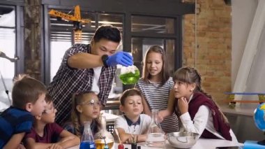 Kimya laboratuvarında kimyasal reaksiyonlarla çalışan altı genç kafkas çocuğundan oluşan ekip