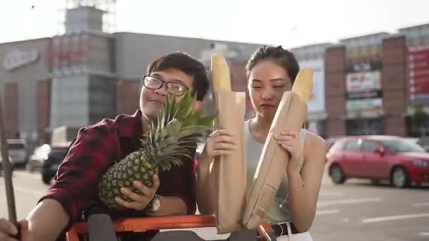 Gut aussehendes vietnamesisches Paar macht amüsantes Selfie mit Sandwich-Rolle und Erdapfel in der Nähe des großen Supermarktes — Stockvideo