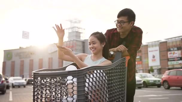 Αξιολάτρευτο ασιατικό ζευγάρι των νέων που περνούν το χρόνο τους με χαρά κοντά μεγάλο εμπορικό κέντρο — Αρχείο Βίντεο
