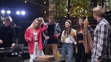 Sevilebilir neşeli 30s arkadaşları gün batımında bahçe evinde düzenlenen serin partide birlikte eğlenmek