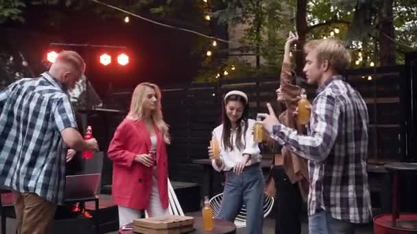 Movimento lento de um grupo de pessoas dançando no gazebo à noite — Vídeo de Stock