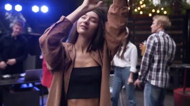 Gün batımında bahçe evinde onu neşeli arkadaşları ile dans kafasına bandana ile Sevimli gülümseyen kadın hipster