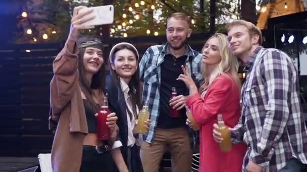 Ganar jóvenes alegres con sonrisas agradables haciendo selfie con caras divertidas en la noche — Vídeo de stock